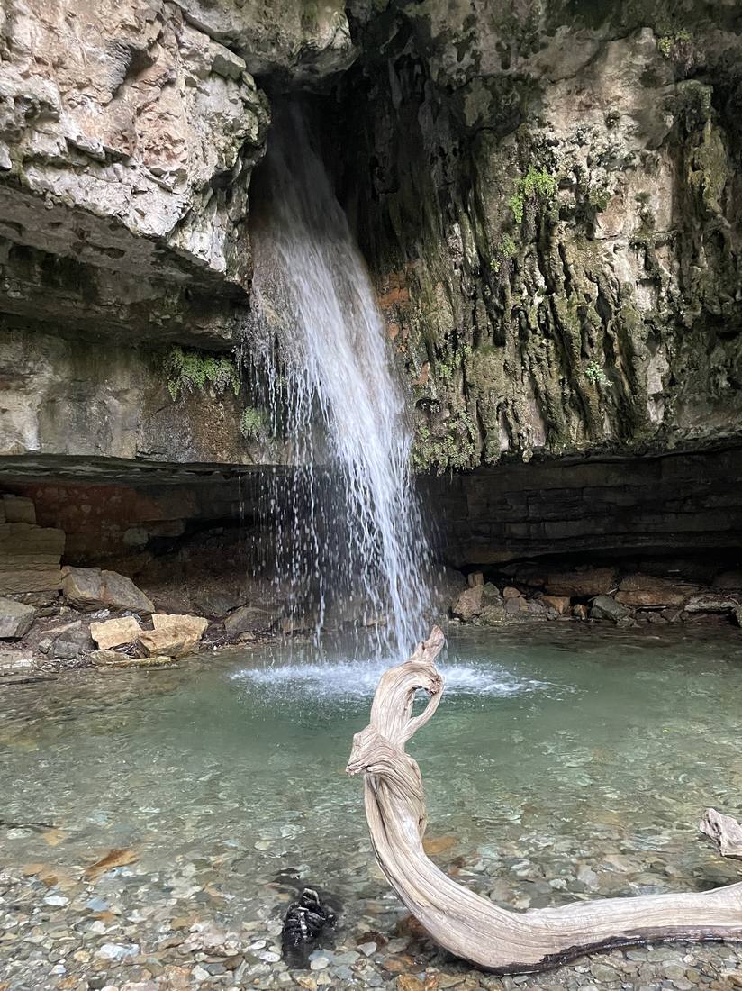 A waterfall from a cave mouth into a pool in the Flumendosa gorge